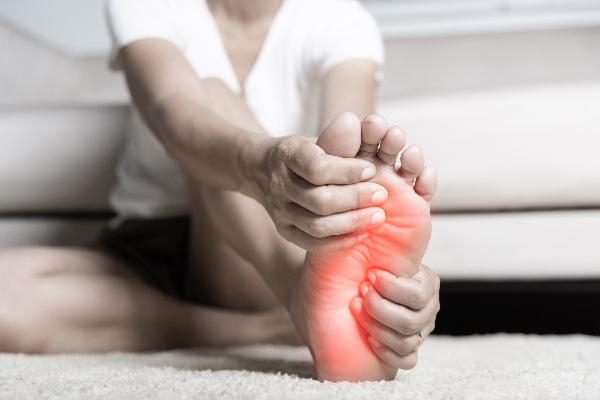  Woman feeling pain in her foot at home.